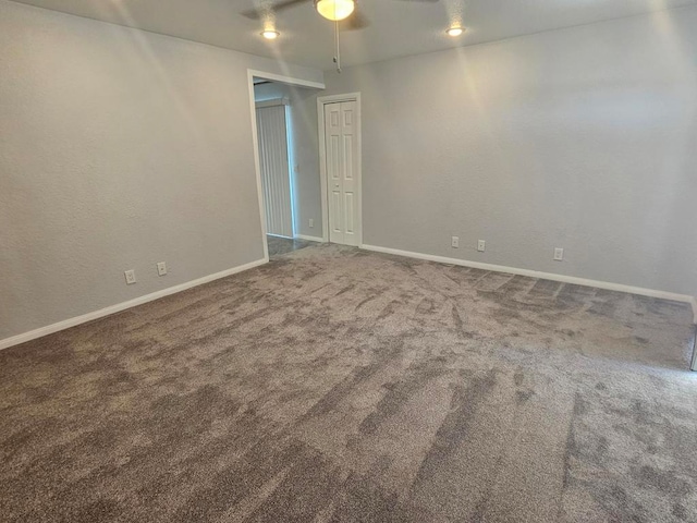 carpeted spare room with ceiling fan