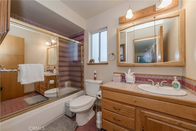 full bathroom featuring vanity, toilet, and bath / shower combo with glass door