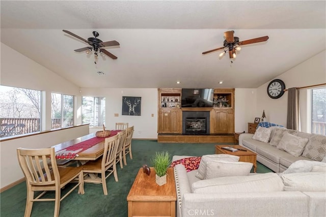 carpeted living room with ceiling fan, a fireplace, and vaulted ceiling