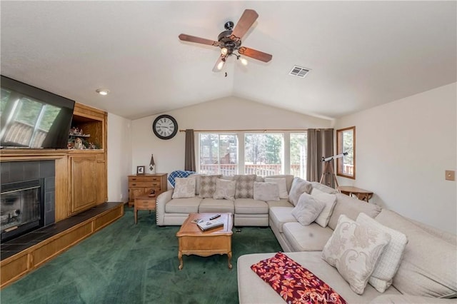 carpeted living room with a tile fireplace, ceiling fan, and lofted ceiling