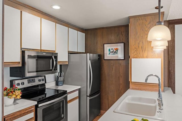 kitchen with white cabinetry, sink, pendant lighting, and appliances with stainless steel finishes