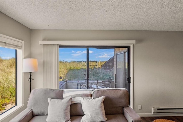 living area featuring hardwood / wood-style floors, a baseboard radiator, and a textured ceiling