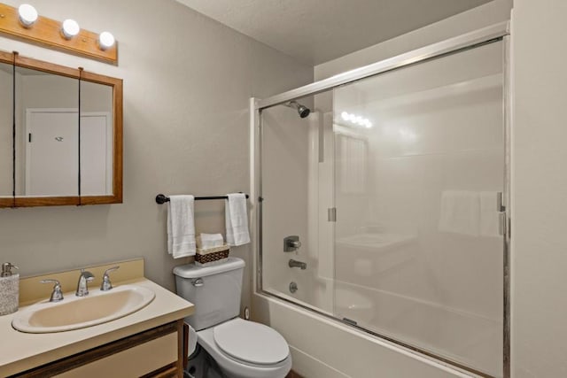 full bathroom with vanity, bath / shower combo with glass door, and toilet