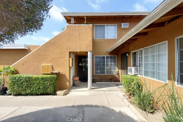 entrance to property with cooling unit and a patio area