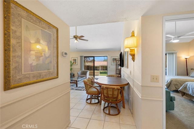 dining area featuring light tile patterned floors, a textured ceiling, vaulted ceiling, and ceiling fan