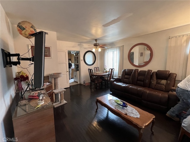 living room with ceiling fan and dark wood-type flooring