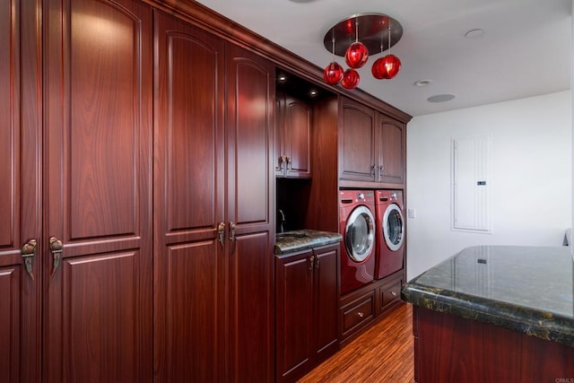 laundry area with dark hardwood / wood-style flooring, independent washer and dryer, cabinets, and sink