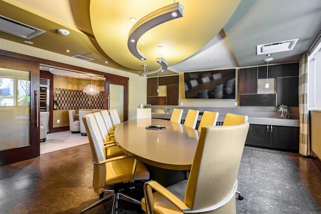 dining area with concrete floors and a chandelier