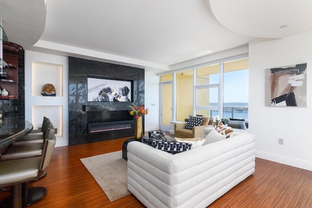 living room with dark hardwood / wood-style flooring and a water view