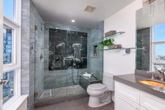 bathroom featuring a healthy amount of sunlight, a shower with shower door, vanity, and toilet