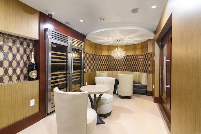 wine room featuring a notable chandelier and light tile floors