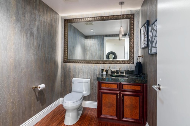 bathroom with toilet, oversized vanity, tile walls, and hardwood / wood-style floors