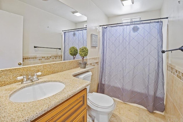 bathroom with tile flooring, oversized vanity, tile walls, and toilet