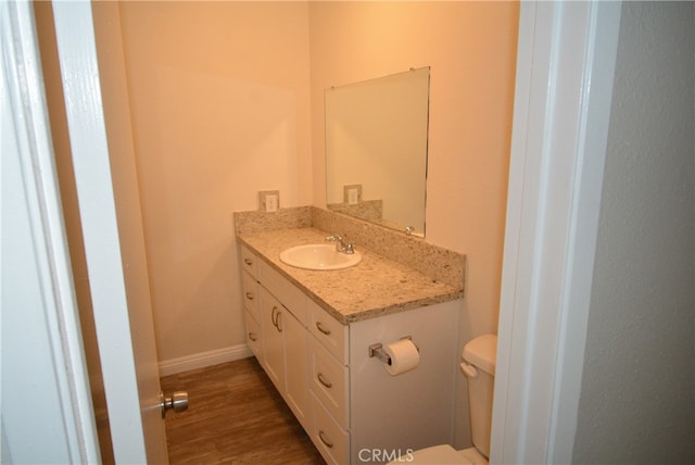 bathroom featuring hardwood / wood-style floors, vanity, and toilet