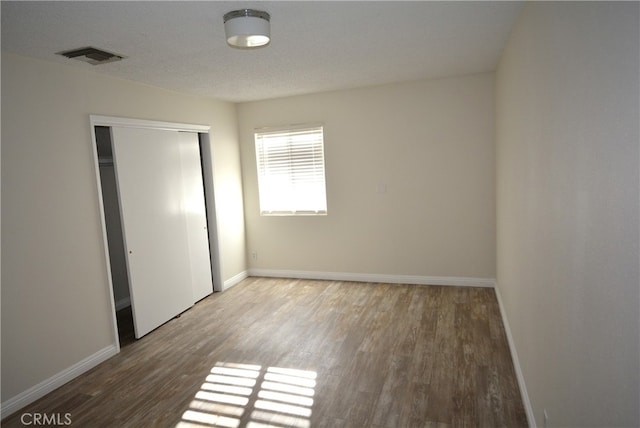 unfurnished bedroom with wood-type flooring and a closet