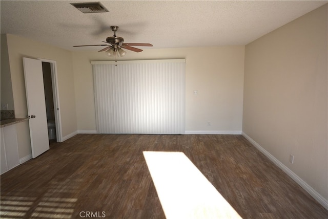 spare room with ceiling fan, dark hardwood / wood-style flooring, and a textured ceiling