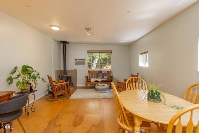 dining area with a wall mounted air conditioner and a wood stove