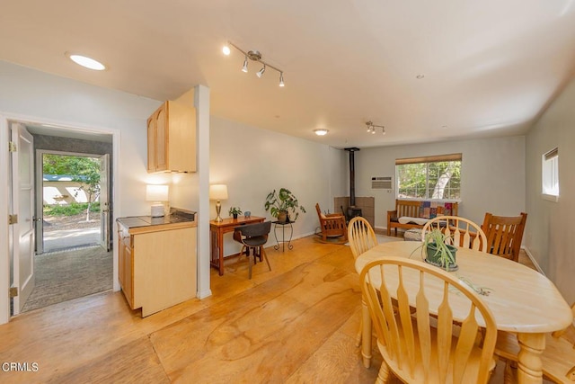 dining space with light wood-type flooring and a wood stove