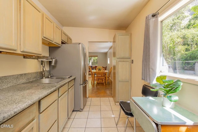 kitchen featuring light tile patterned floors, a wealth of natural light, light brown cabinetry, and sink