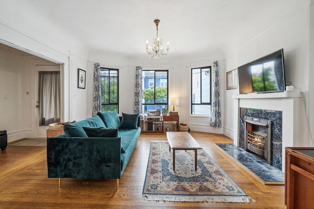 living room with hardwood / wood-style flooring, a notable chandelier, and a fireplace