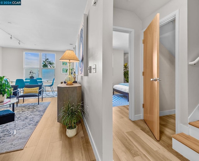 hall featuring track lighting and hardwood / wood-style floors