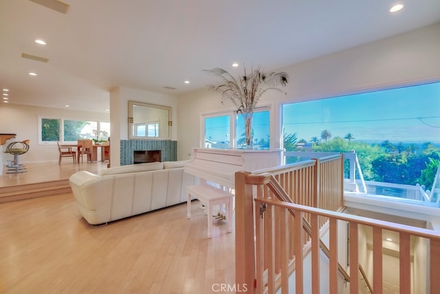 living room featuring a tiled fireplace and light hardwood / wood-style floors