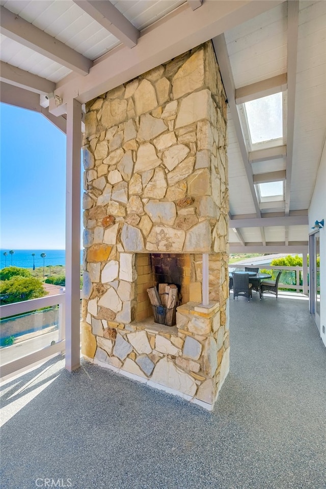 interior space with beamed ceiling and a water view