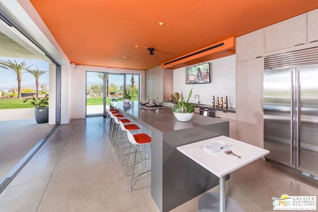 kitchen with a breakfast bar area, sink, a kitchen island, and appliances with stainless steel finishes