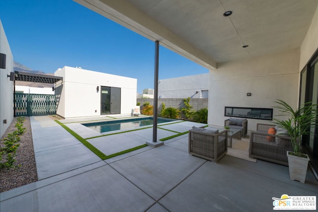 view of pool with an outdoor living space with a fireplace and a patio