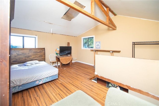 bedroom featuring hardwood / wood-style floors and lofted ceiling with beams