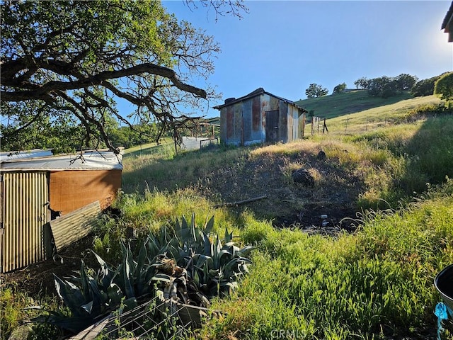 view of yard with a rural view and an outdoor structure