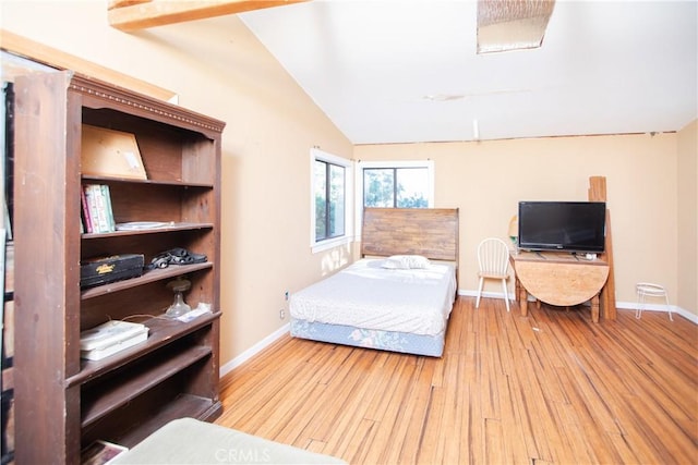 bedroom featuring lofted ceiling and light wood-type flooring