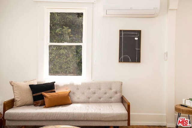 living area with an AC wall unit and a healthy amount of sunlight