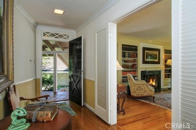 doorway to outside with ornamental molding and hardwood / wood-style flooring