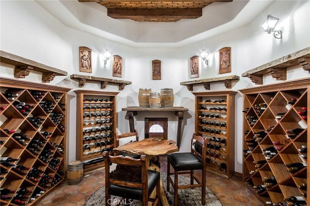 wine area featuring beam ceiling and a raised ceiling