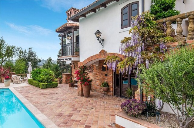 back of property with a balcony and a patio area