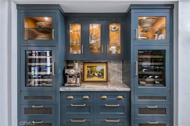 bar featuring decorative backsplash, blue cabinetry, and beverage cooler