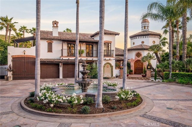 mediterranean / spanish house featuring a balcony and a garage