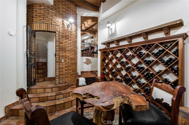 wine cellar featuring beamed ceiling