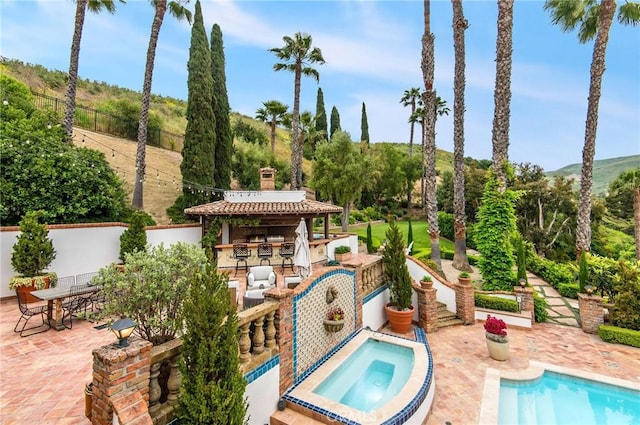 view of swimming pool featuring a gazebo, an in ground hot tub, a bar, and a patio