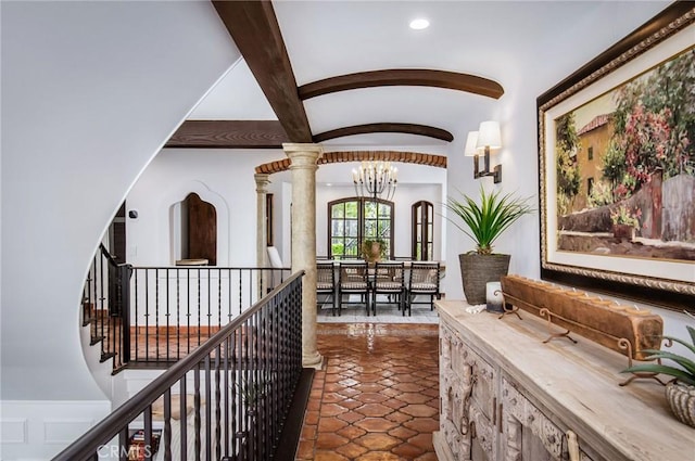 hallway with beam ceiling, decorative columns, an inviting chandelier, and dark tile patterned flooring