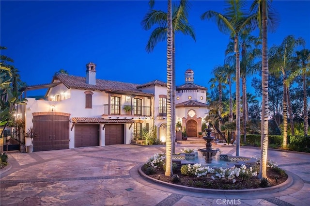 mediterranean / spanish house with a balcony and a garage