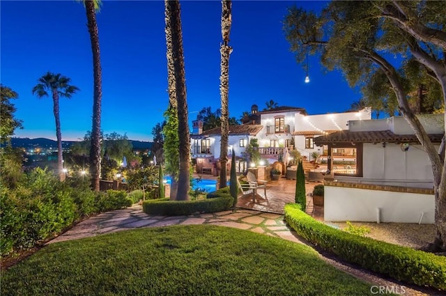 yard at dusk featuring a patio area and a swimming pool