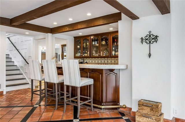 bar with beam ceiling, tasteful backsplash, and tile patterned floors