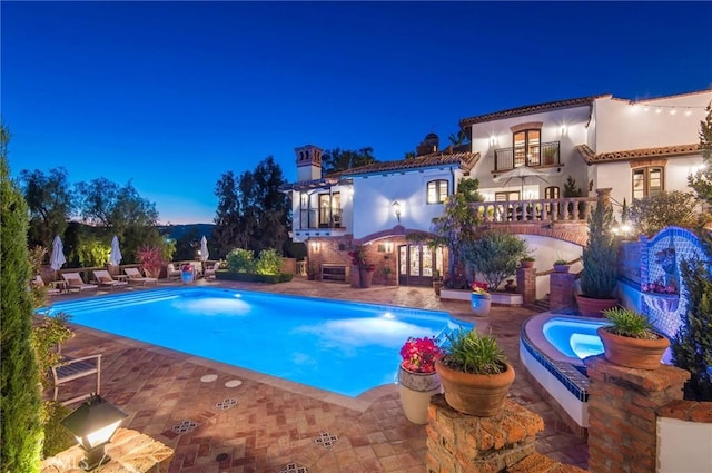 pool at dusk with a patio