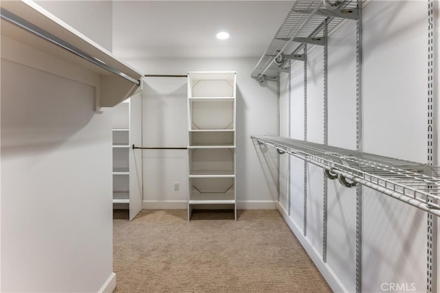 walk in closet featuring light carpet