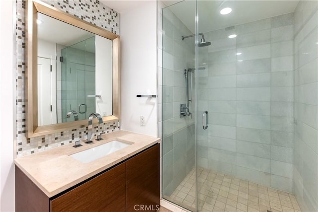 bathroom with vanity, backsplash, and walk in shower