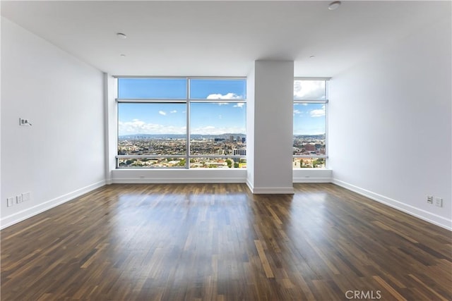 unfurnished room featuring dark hardwood / wood-style flooring and a wall of windows