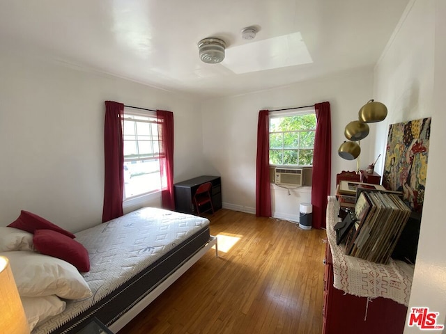 bedroom with a skylight and wood-type flooring