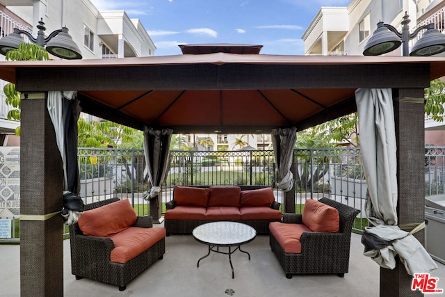 view of terrace featuring an outdoor living space, a balcony, and a gazebo